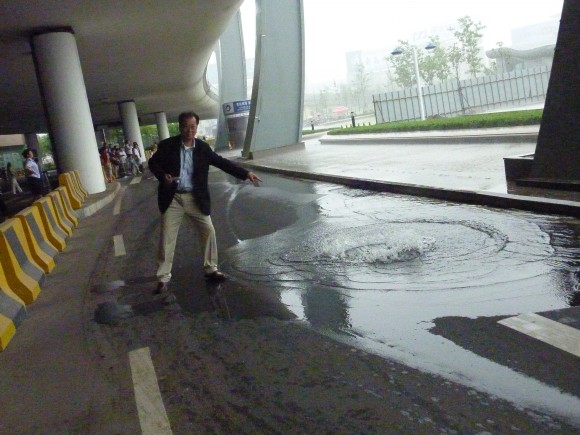 青島空港送迎用道路雨水で溢れる その状況を指す塩野靖氏